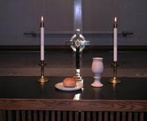 Photo of church table with cross, candles, goblet, and bread